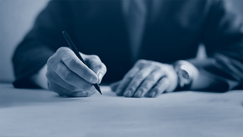 Film financing executive signs paperwork on a production loan.